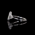 Marquise diamond engagement ring with floral side stones on black background