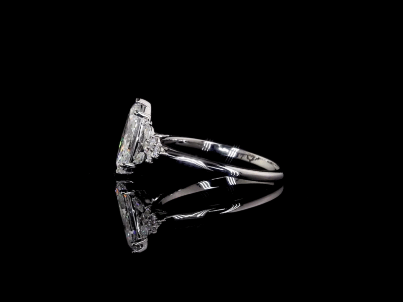 Marquise diamond engagement ring with floral side stones on black background